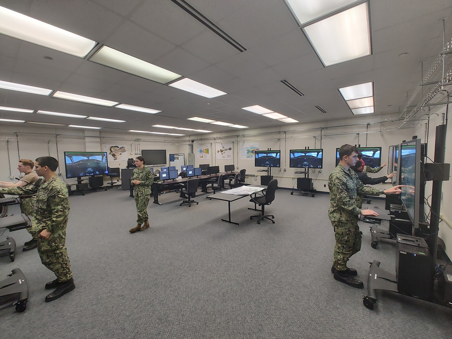 Aviation Machinist Mate First Class Lexus Himes, a Center for Naval Aviation Technical Training instructor, oversees students practicing conducting maintenance on the E-6B Mercury using the new virtual Multi-Purpose Reconfigurable Training System 3D Panel Trainers at Tinker Air Force Base, Oklahoma.