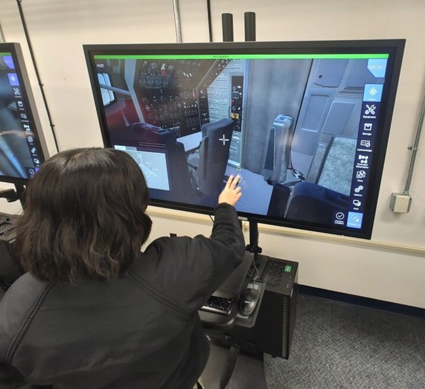 Aviation Machinist’s Mate Airman Maribel Lopez working inside a virtual E-6B Mercury using the new Multi-Purpose Reconfigurable Training System 3D Panel Trainers at Tinker Air Force Base, Oklahoma.