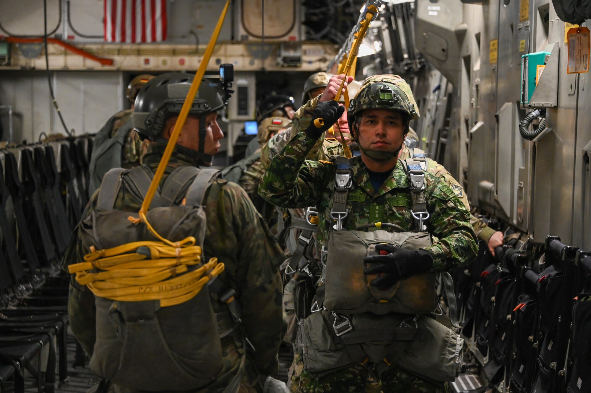 A National Army of Colombia jumpmaster positions himself for the airdrop over Drop Zone Sicily at Fort Liberty, North Carolina, Dec. 9, 2024. Members of the National Army of Colombia joined Polish Armed Forces members on a C-17 Globemaster III aircraft out of the 58th Airlift Squadron. (U.S. Air Force photo by Senior Airman Kari Degraffenreed)