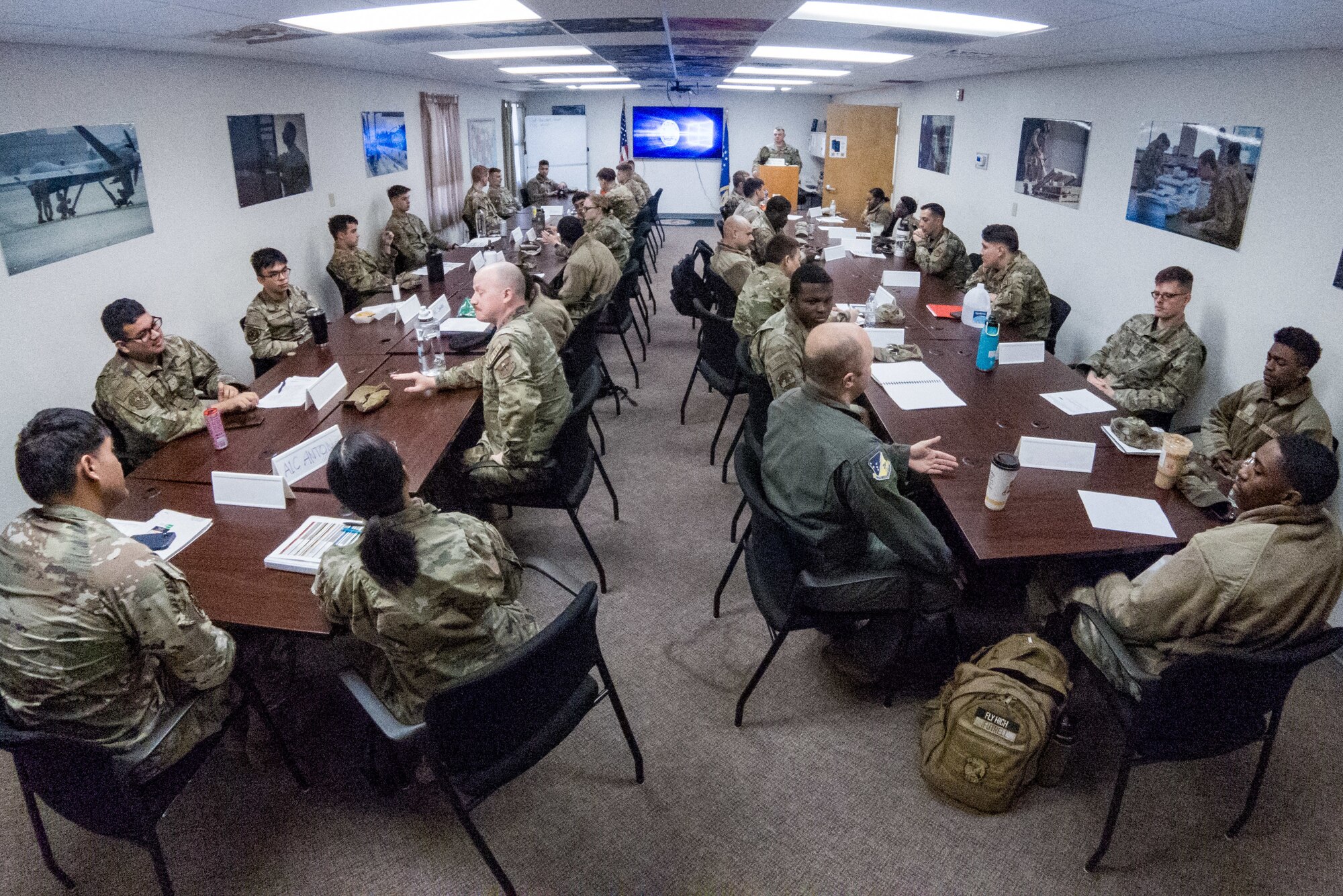 An overhead view of the First Term Enlisted Course mentor session classroom with junior Airmen and guests.