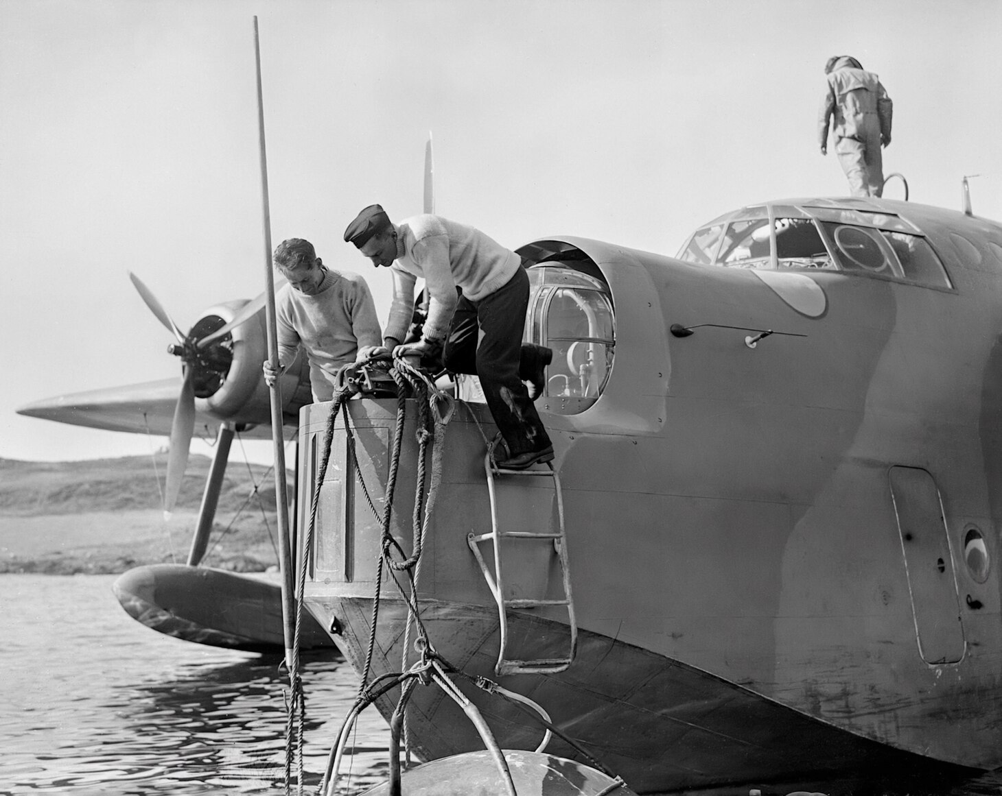 Like most WWII-era flying boats, the Sunderland had a bow turret that could slide back to allow the crew access to a mooring in the water ahead of the aircraft. In this photo, crew members secure their aircraft to its mooring buoy.