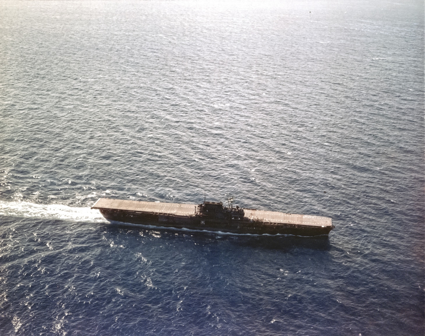 USS Enterprise (CV-6) Operating in the Pacific, circa late June 1941. She is turning into the wind to recover aircraft. Note her natural wood flight deck stain and dark Measure One camouflage paint scheme. The flight deck was stained blue in July 1941, during camouflage experiments that gave her a unique deck stripe pattern.  Official U.S. Navy Photograph, now in the collections of the National Archives.