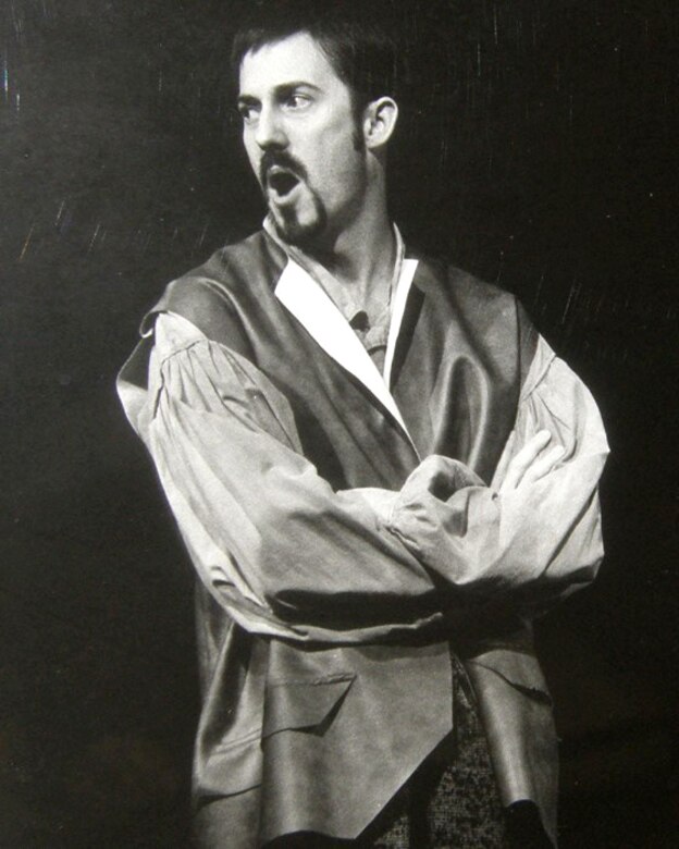 A man poses for a theatrical photo wearing the garb of a commoner in early 19th century France