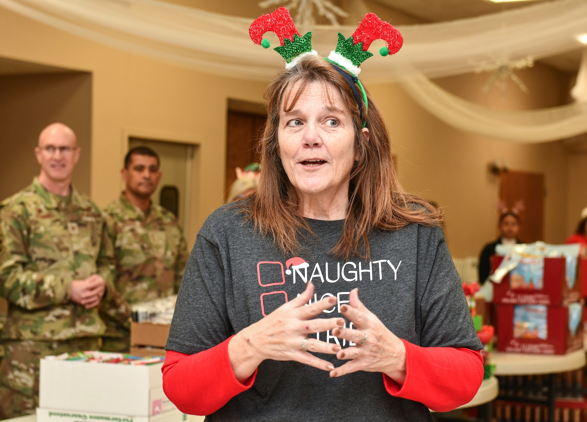 Diane Bruce, Bellevue Chamber of Commerce president, welcomes Operation Holiday Cheer volunteers at the Bellevue Volunteer Fire Department on Dec. 11, 2024. Operation Holiday Cheer brought over 40 local community leaders and Offutt Airmen together to pack 480 gift bags for dormitory residents. (U.S. Air Force photo by Chad Watkins)
