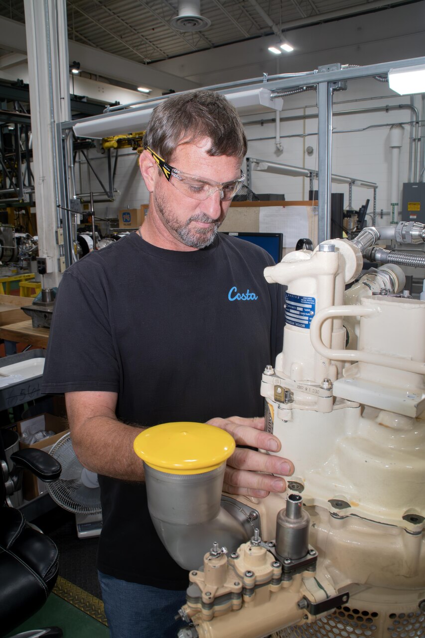 Ryan McNeil, a pneudralics systems mechanic at Fleet Readiness Center East (FRCE) works on an auxiliary power unit used in the F/A-18E/F Super Hornet. FRCE recently achieved a significant production milestone by eliminating high-priority backorders for auxiliary power units used in the Super Hornet, bolstering the platform’s mission readiness. Challenges related to the availability of parts and materials used in the auxiliary power unit threatened to keep a number of Super Hornets on the ground. The depot eliminated all high-priority backorders within a 12-month time frame. (Photo by Joe Andes, Fleet Readiness Center East Public Affairs.)