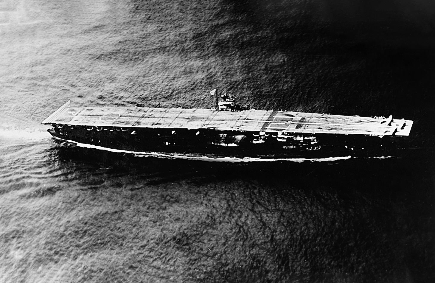 IJN Akagi at sea during the Summer of 1941, with three Mitsubishi A6M Zero fighters parked forward.