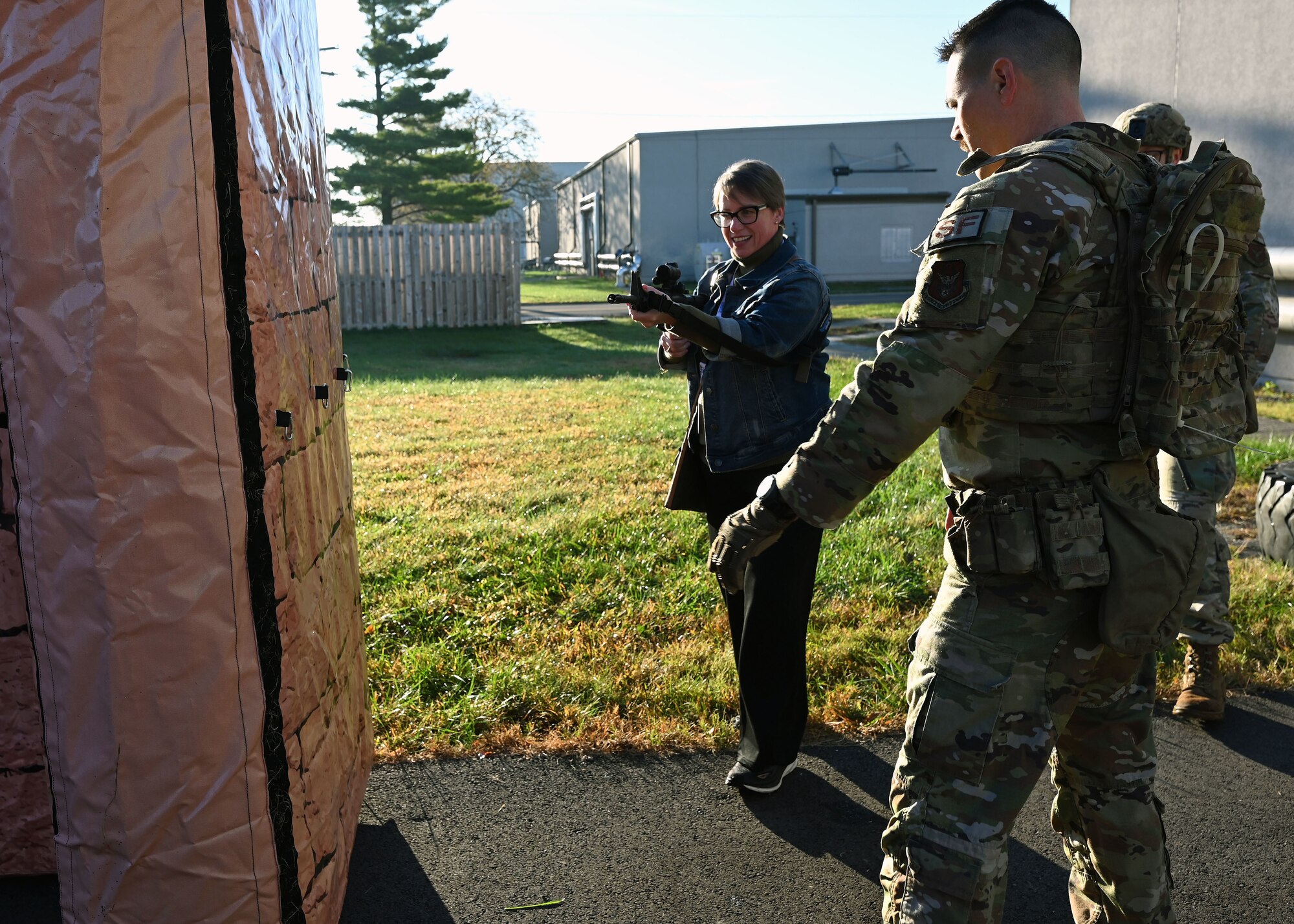 U.S. Air Force Tech. Sgt. Joel Ford, right, 445th Security Forces Squadron fire team leader, instructs Carla Caton, employer of U.S. Air Force Maj. Daniel Shields with the 445th Aeromedical Staging Squadron, how to breach a door in a simulated urban environment during Employers Day at Wright-Patterson Air Force Base, Nov. 2, 2024. Civilian employees of Citizen Airmen were able to practice securing a building after being instructed by 445th SFS Airmen on proper maneuvers. (U.S. Air Force photo by Amanda Dick)