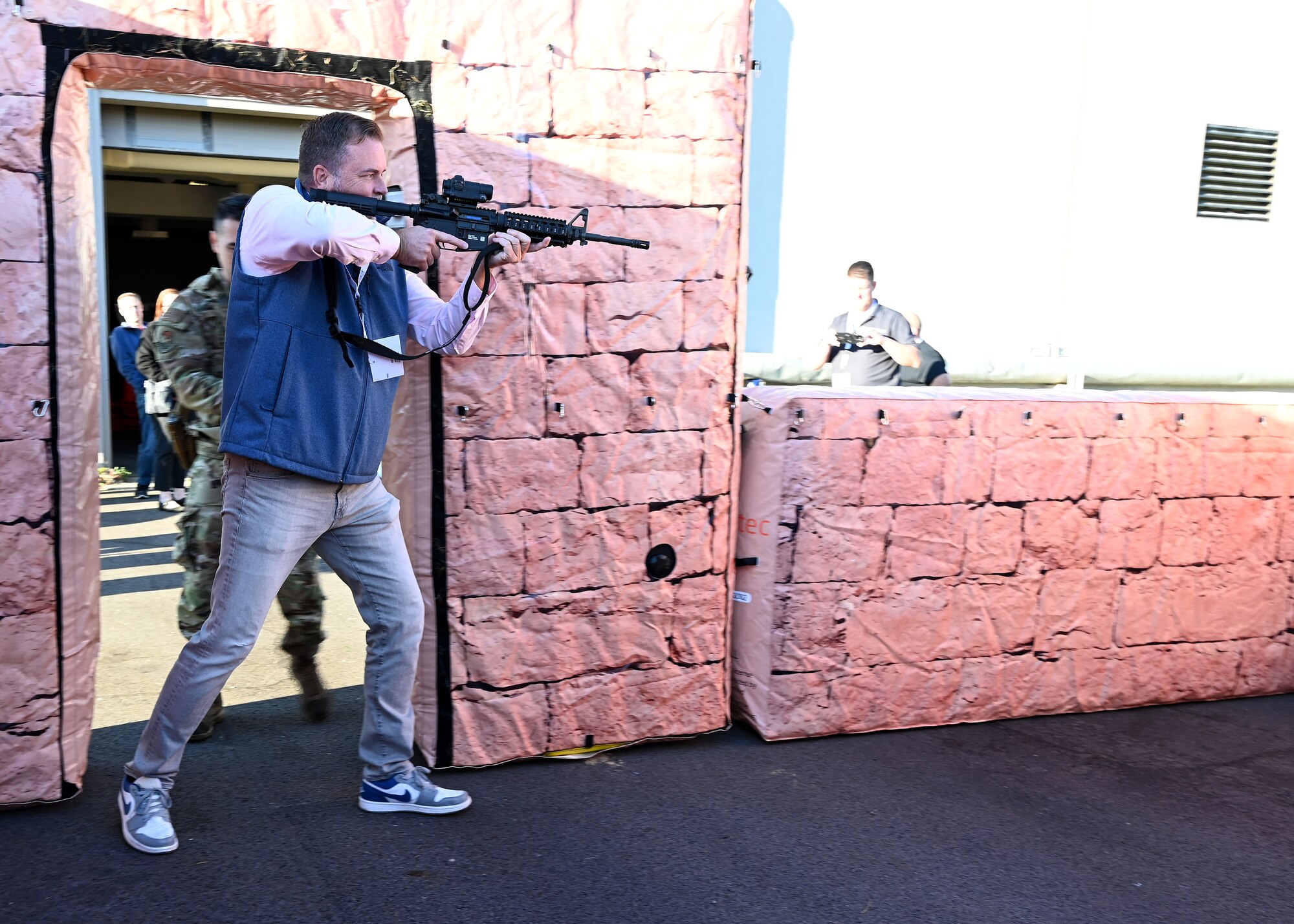 Kevin Brooks, employer of U.S. Air Force Tech. Sgt. Joseph Divish with the 87th Aerial Port Squadron, breaches a door in a simulated urban environment during Employers Day at Wright-Patterson Air Force Base, Nov. 2, 2024. Civilian employees of Citizen Airmen were able to practice securing a building after being instructed by 445th Security Forces Airman Airmen on proper maneuvers. (U.S. Air Force photo by Amanda Dick)