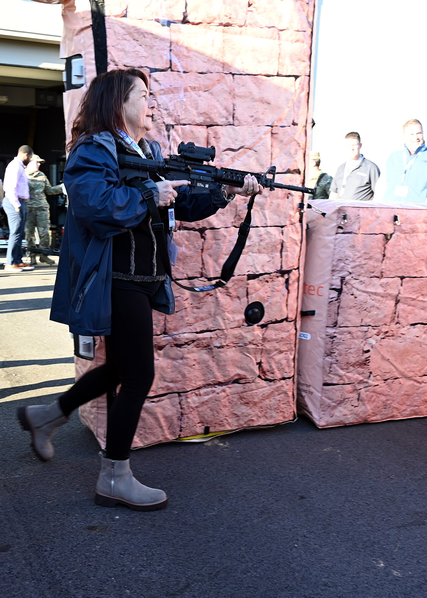 Karen Spaulding-Chicketti, employer of U.S. Air Force Master Sgt. Michelle Lee with the 445th Aeromedical Staging Squadron, breaches a door in a simulated urban environment during Employers Day at Wright-Patterson Air Force Base, Nov. 2, 2024. Civilian employees of Citizen Airmen were able to practice securing a building after being instructed by 445th Security Forces Airman Airmen on proper maneuvers. (U.S. Air Force photo by Amanda Dick)