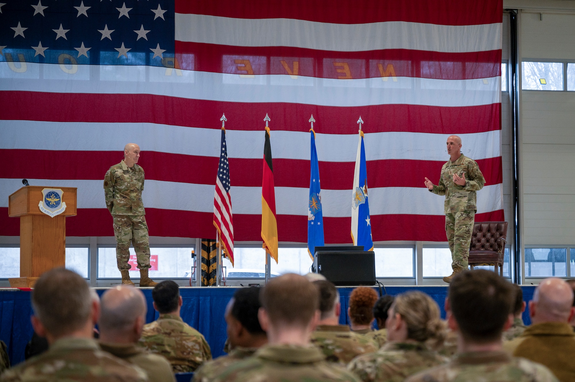 Military leadership briefs a crowd.