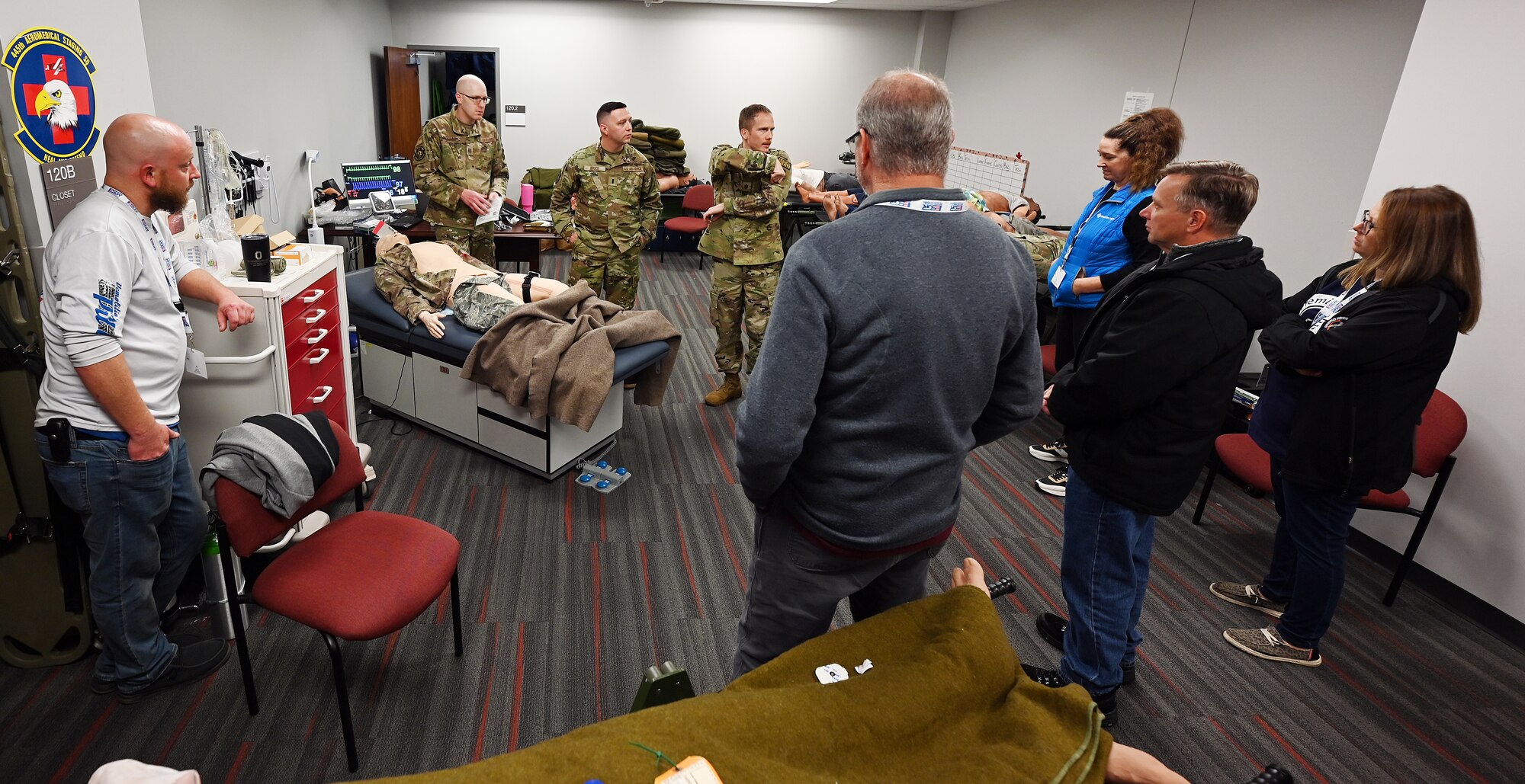 Citizen Airmen with the 445th Aeromedical Staging Squadron highlight the capabilities of a medical dummy used for training to civilian employees of Citizen Airmen during Employers Day at Wright-Patterson Air Force Base, Nov. 2, 2024. Employers Day recognizes the contribution employers make to the Air Force Reserve by highlighting various mission sets of the wing and providing an orientation flight on a C-17 Globemaster III aircraft. (U.S. Air Force photo by Amanda Dick)