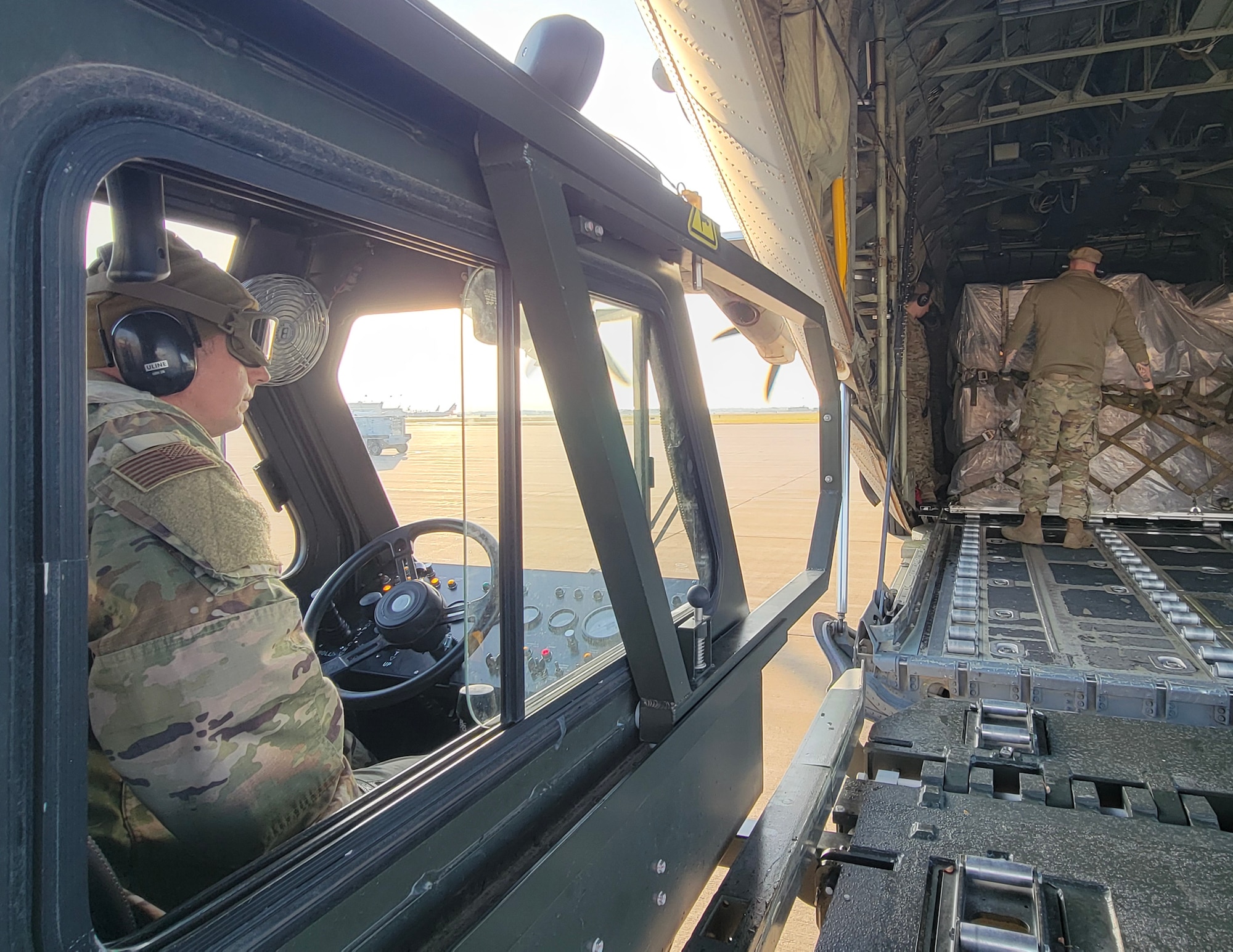 U.S. Air Force Master Sgt. Jesse McLean, left, 133rd Air Transportation Function, drives the halvorson k-loader to the C-130 Herucles in St. Paul, Minn., Nov. 6, 2024.