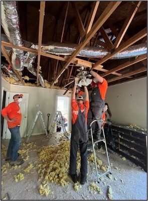 Three MK A-school students assist with Hurricane Helene recovery by working on ceiling rafters.