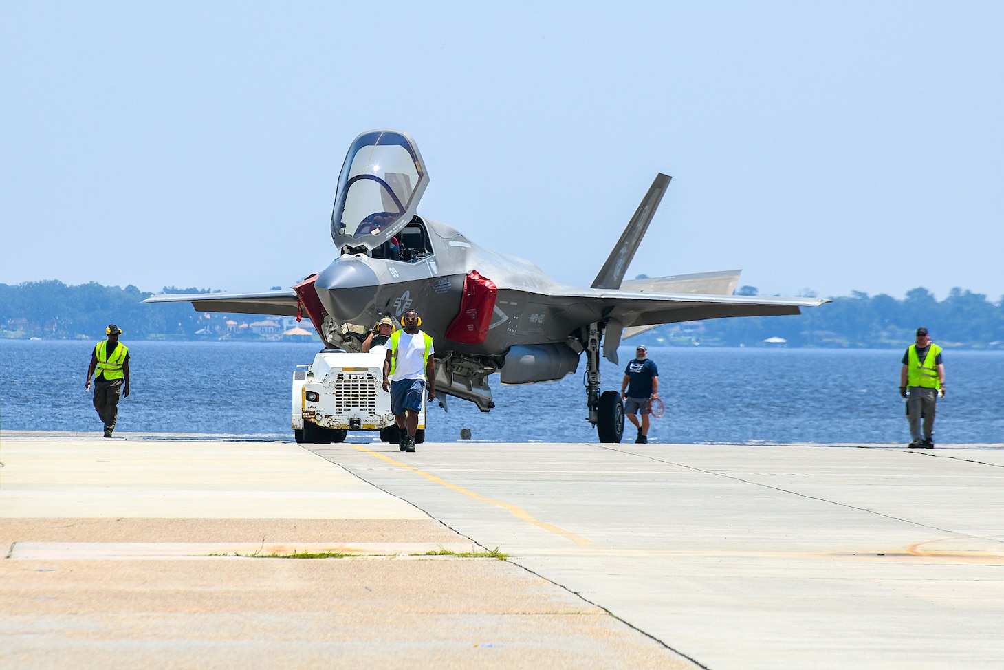 JACKSONVILLE, Fla. (Aug. 08, 2024) Personnel from Fleet Readiness Center Southeast (FRCSE) tow an F-35B Lightning II that was recently delivered from Marine Fighter Attack Squadron 122 at Yuma, Ariz. The jet is the first F-35 ever inducted into the depot and is part of a readiness improvement initiative to support corrosion mitigation efforts for the U.S. Marine Corps (USMC). (U.S. Navy photo by Toiete Jackson/Released)