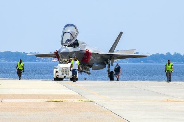 JACKSONVILLE, Fla. (Aug. 08, 2024) Personnel from Fleet Readiness Center Southeast (FRCSE) tow an F-35B Lightning II that was recently delivered from Marine Fighter Attack Squadron 122 at Yuma, Ariz. The jet is the first F-35 ever inducted into the depot and is part of a readiness improvement initiative to support corrosion mitigation efforts for the U.S. Marine Corps (USMC). (U.S. Navy photo by Toiete Jackson/Released)