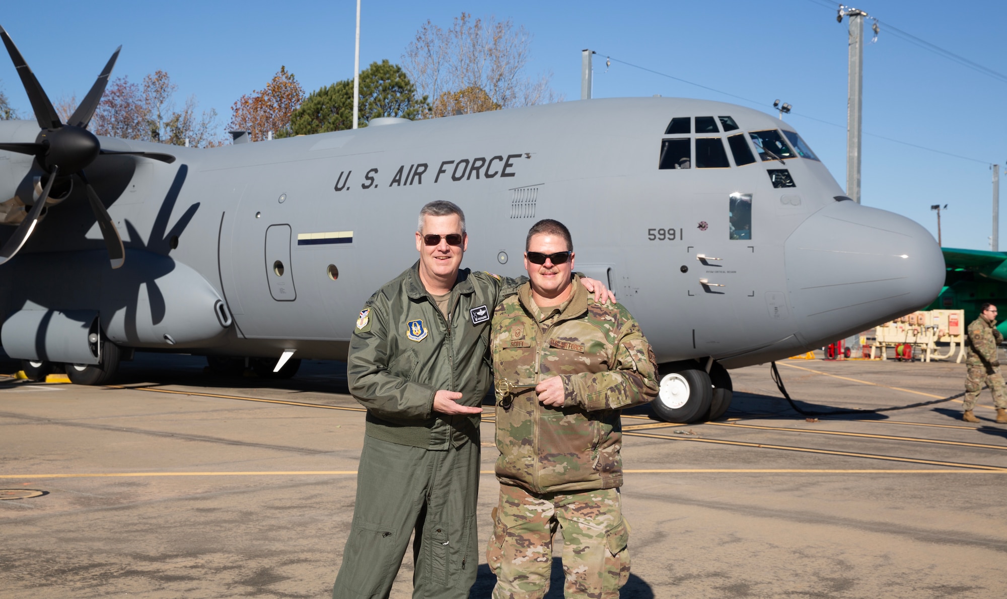 910th Airlift Wing Commander Col. Mike Maloney poses for a photo with Master Sgt. Dan Scott, dedicated crew chief assigned to the 910th Aircraft Maintenance Squadron, holding a ceremonial aircraft key in front of the unit’s newest C-130J-30 Super Hercules aircraft at the Lockheed Martin assembly plant in Marietta, Georgia, Dec. 6, 2024.