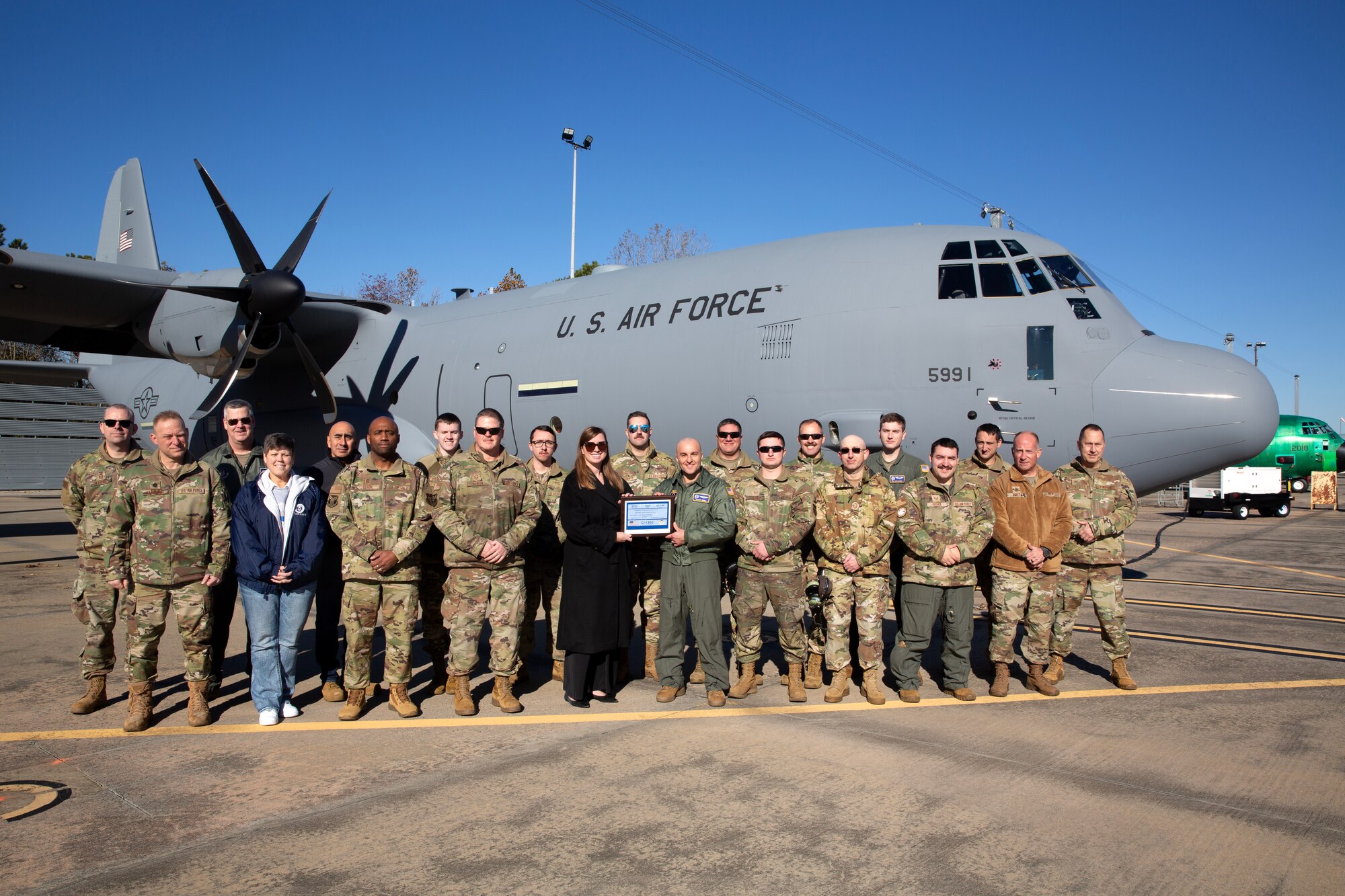Representatives of the 910th Airlift Wing pose for a photo with a representative from Lockheed Martin in front of the unit’s newest C-130J-30 Super Hercules aircraft at the Lockheed Martin assembly plant in Marietta, Georgia, Dec. 6, 2024.