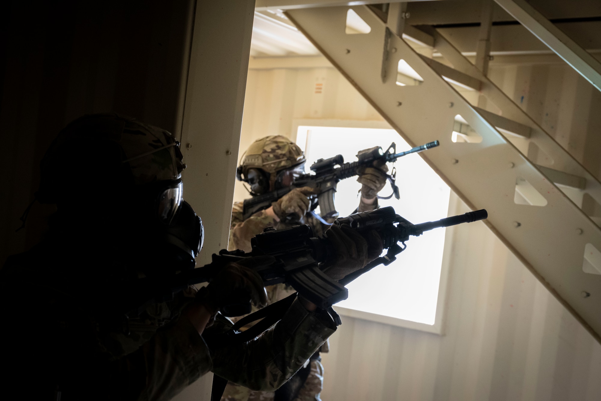 Airmen assigned to the 49th Security Forces Squadron prepare to clear a staircase during the "Regulator Rodeo" exercise at Holloman Air Force Base, New Mexico, Dec. 3, 2024. The "Regulator Rodeo" is an annual training exercise at Holloman, simulating potential missions to prepare Airmen for securing and sustaining combat operations in contested regions. (U.S. Air Force photo by Senior Airman Isaiah Pedrazzini)