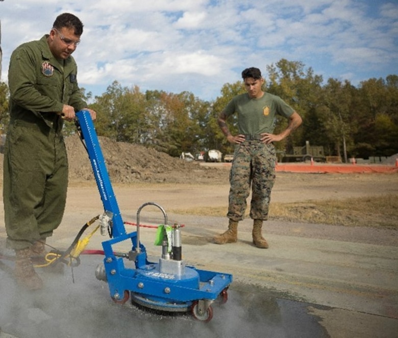 Marines from the Marine Wing Support Squadron 271, 2nd Marine Aircraft Wing operate prototype high pressure surface removal equipment during the Airfield Matting Resurfacing experiment at the U.S. Army Engineer Research and Development Center.