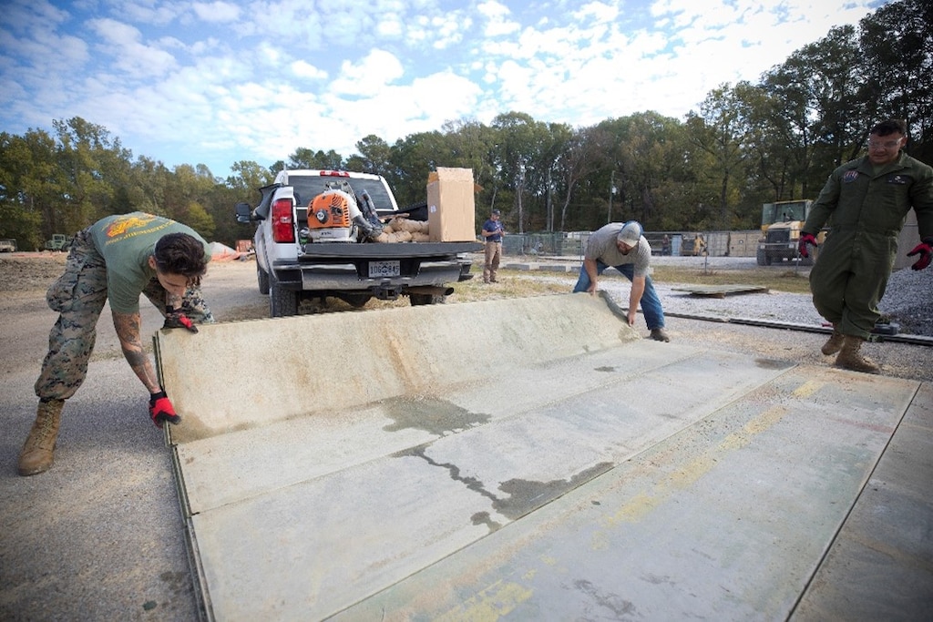 Marines from the Marine Wing Support Squadron 271, 2nd Marine Aircraft Wing assemble AM2 matting during the Airfield Matting Resurfacing experiment at the U.S. Army Engineer Research and Development Center.