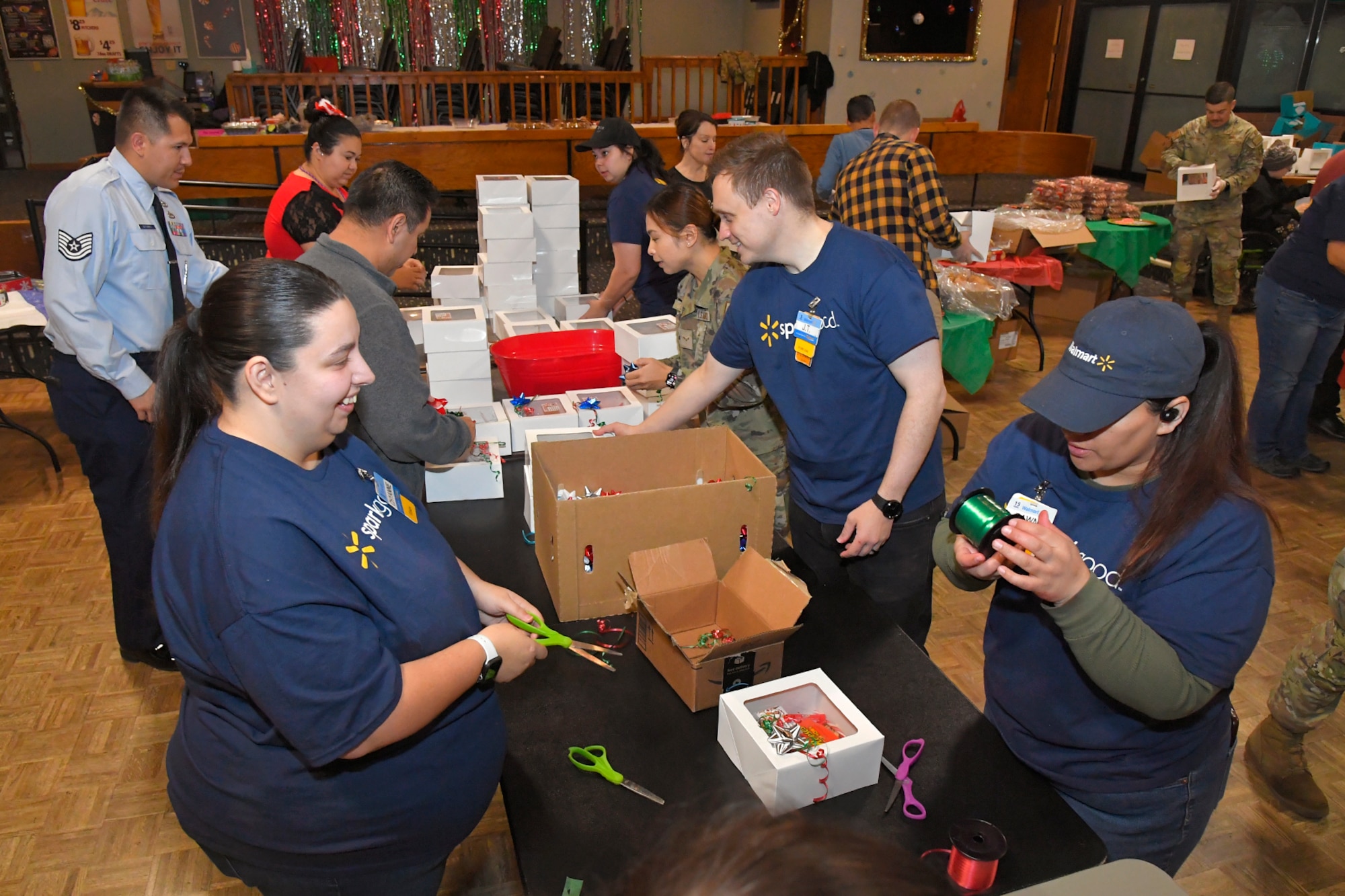 Walmart volunteers tie ribbons and decorate holiday cookie packages donated by the community during the annual Team Hill Cookie Drive at Hill Air Force Base, Utah, Dec. 16, 2024. Organized volunteers representing the 388th Fighter Wing, 75th Air Base Wing, and many other units on base, along with community volunteers, came together to show support and spread holiday cheer among Airmen living in the dormitories and working in units throughout the installation. (U.S. Air Force photo by Todd Cromar)