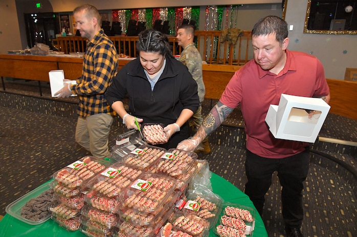 (Left to right) Volunteers Nichole Darrio, representing 75th Operations Support Squadron, and Glen Clark, 75th Air Base Wing Safety Office, box up holiday cookie packages donated by the community during the annual Team Hill Cookie Drive at Hill Air Force Base, Utah, Dec. 16, 2024. Organized volunteers representing the 388th Fighter Wing, 75th Air Base Wing, and many other units on base, along with community volunteers, came together to show support and spread holiday cheer among Airmen living in the dormitories and working in units throughout the installation. (U.S. Air Force photo by Todd Cromar)