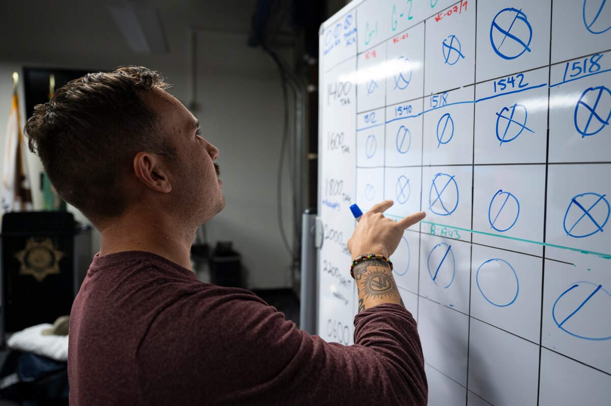 U.S. Air Force 1st Lt. Joel Sanchez-Rosado, 818th Mobility Support Advisory Squadron air advisor, updates a communications check white board during Exercise Sourdough in San Francisco, California, Dec. 4, 2024.