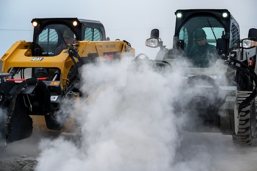 U.S. Air Force and Japan Air Self-Defense Force members operate heavy equipment side-by-side.