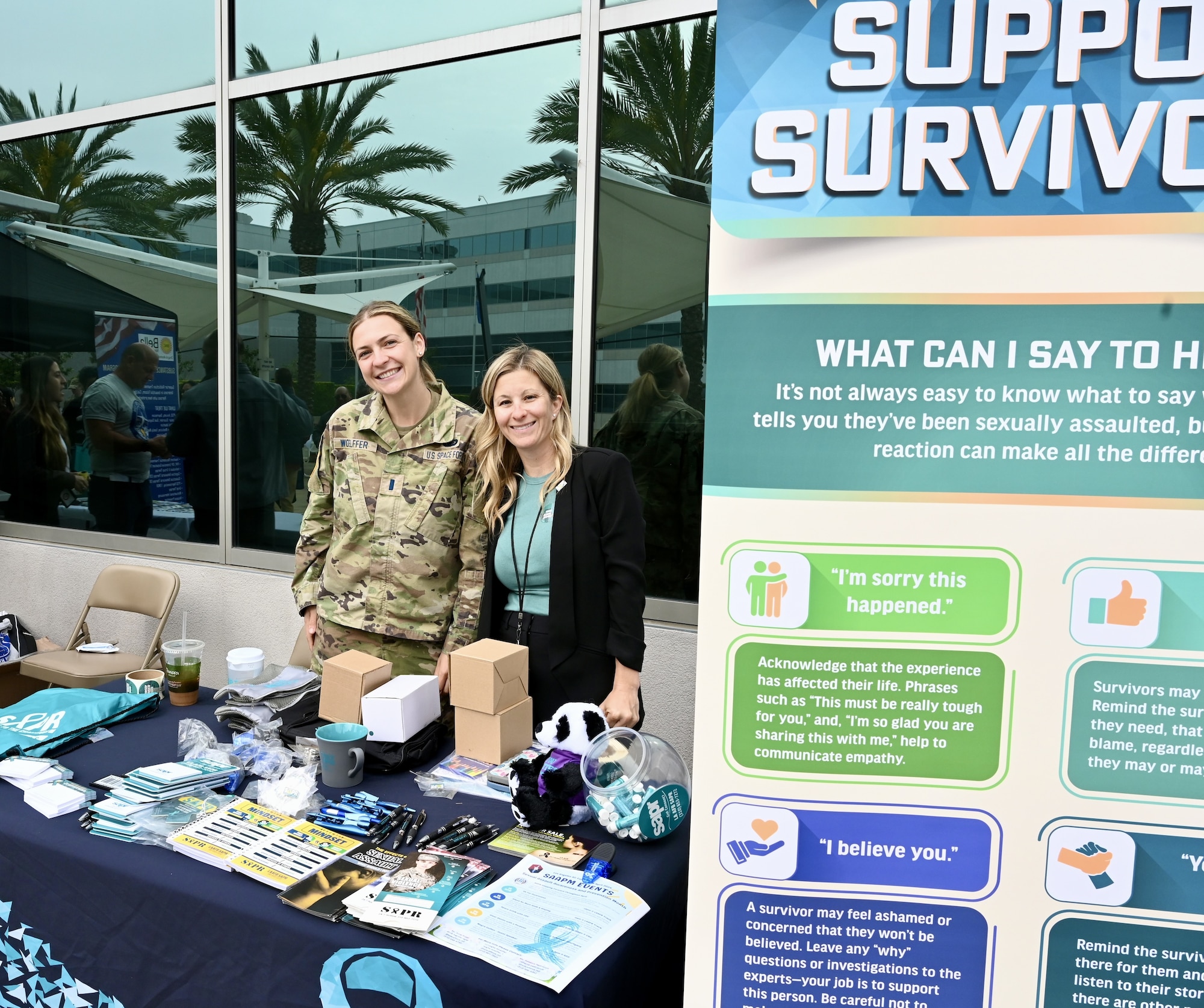 Two women stand at a booth publicizing the Sexual Assault Prevention and Response office.