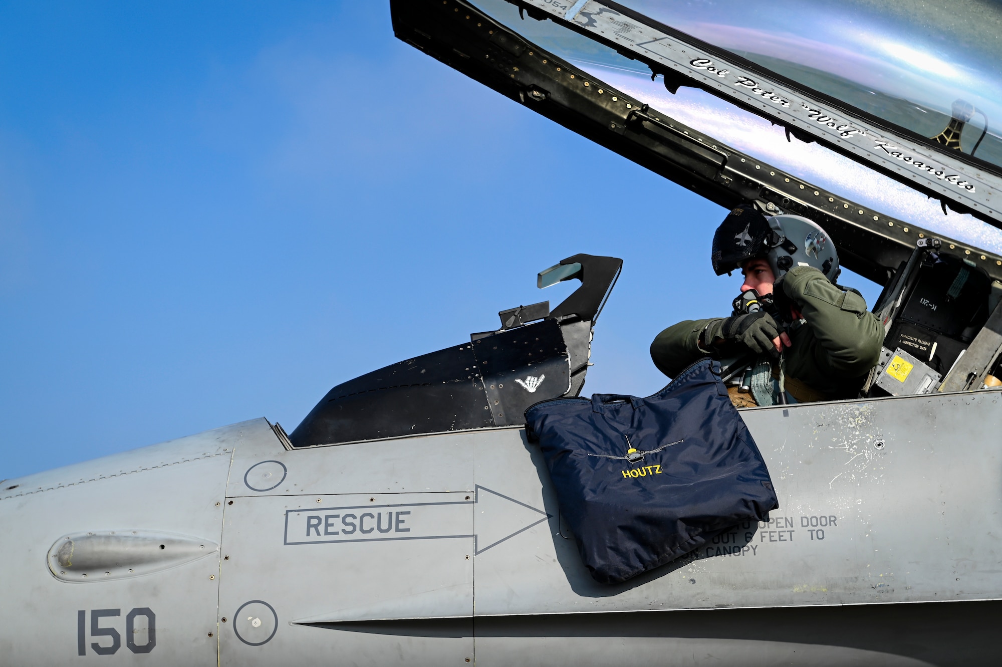 A pilot puts on his helmet