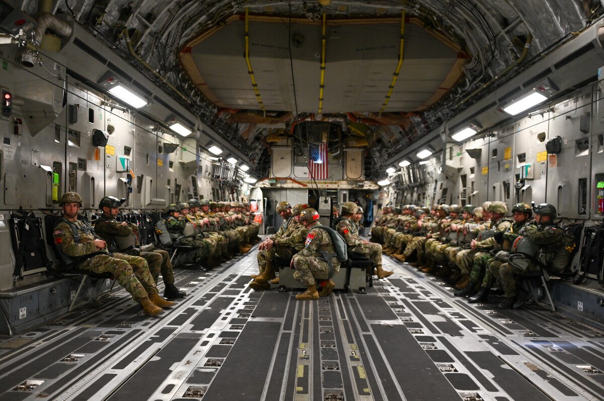 U.S. Army, U.S. Army Reserve, Polish Armed Forces, and National Army of Colombia jumpmasters prepare to jump out of a C-17 Globemaster III aircraft over Drop Zone Sicily on Fort Liberty, North Carolina, Dec. 9, 2024. The team from the 58th Airlift Squadron assisted in the validation of more than 90 personnel during the two-day mission. (U.S. Air Force photo by Senior Airman Kari Degraffenreed)