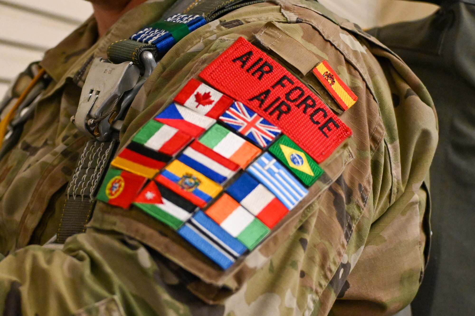 U.S. Air Force Tech. Sgt. Jesse Clark, 18th Air Support Operations Group combat aviation brigade noncommissioned officer in charge, shows off his patch sleeve with flags from multiple partner nations at Fort Liberty, North Carolina, Dec. 9, 2024. U.S. Soldiers and Airmen are encouraged to trade patches with their foreign counterparts to build camaraderie. (U.S. Air Force photo by Senior Airman Kari Degraffenreed)