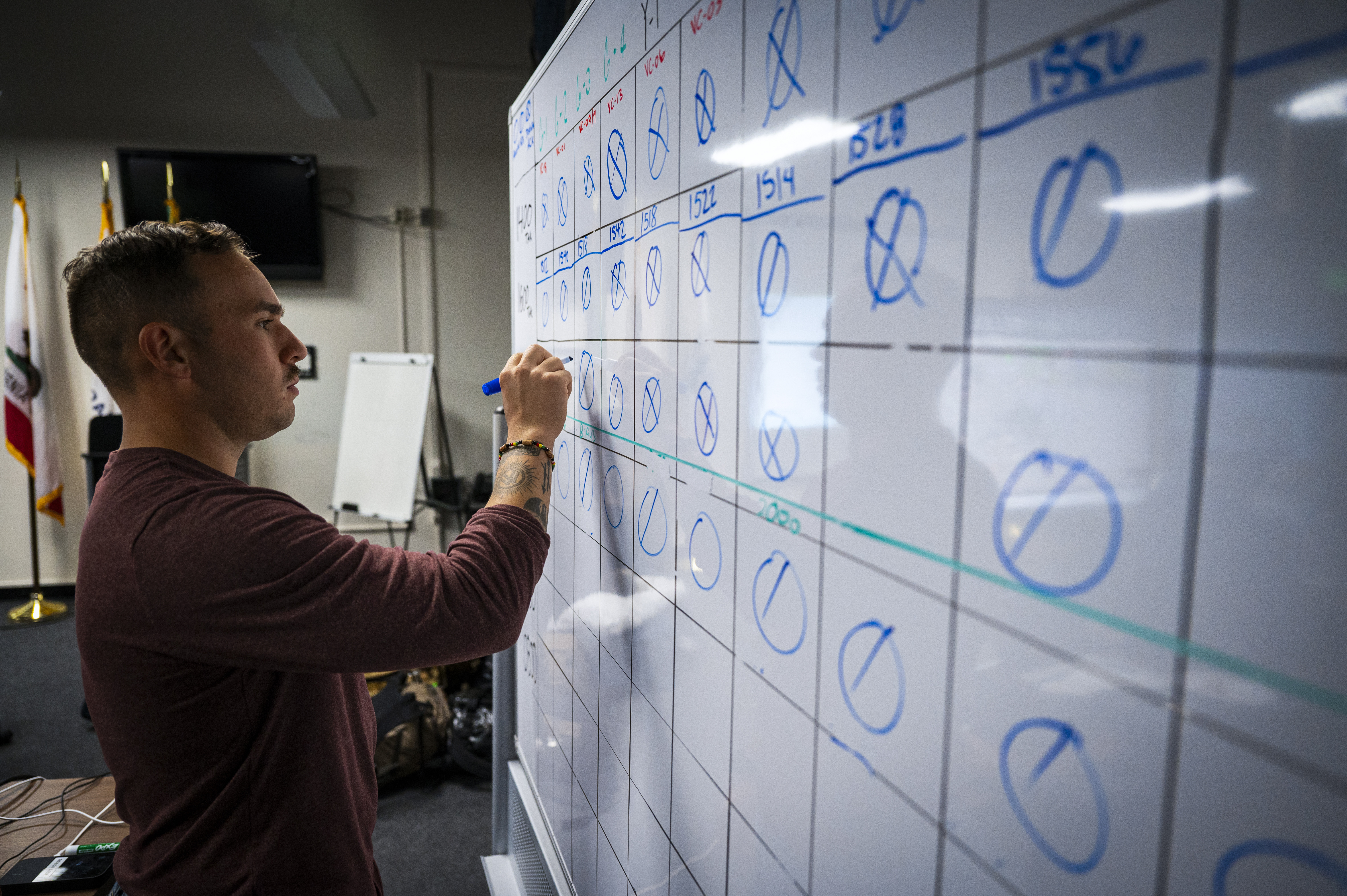 U.S. Air Force 1st Lt. Joel Sanchez-Rosado, 818th Mobility Support Advisory Squadron deputy chief of weapons and tactics, updates a communications check white board during Exercise Sourdough in San Francisco, California, Dec. 4, 2024.