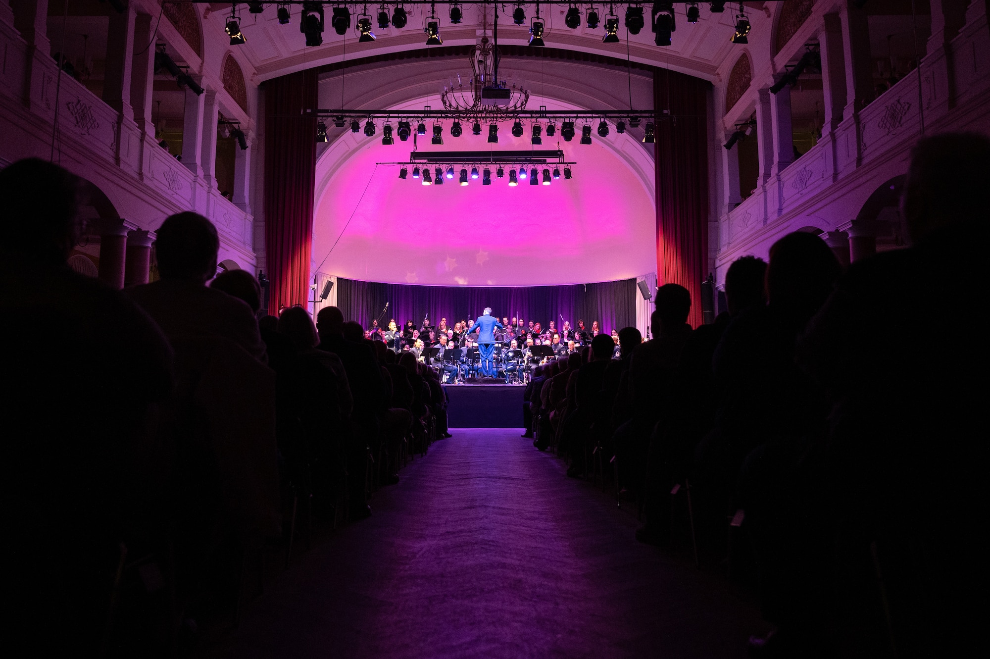 Local community members applaud  the U.S. Air Forces in Europe - Air Forces Africa Band during the Kaiserslautern Military Community Christmas concert at the Fruchthalle in Kaiserslautern, Germany, Dec. 13, 2024. Events such as these sustain interoperability and preserve long standing relationships with allies. (U.S. Air Force photo by Senior Airman Renan Arredondo)