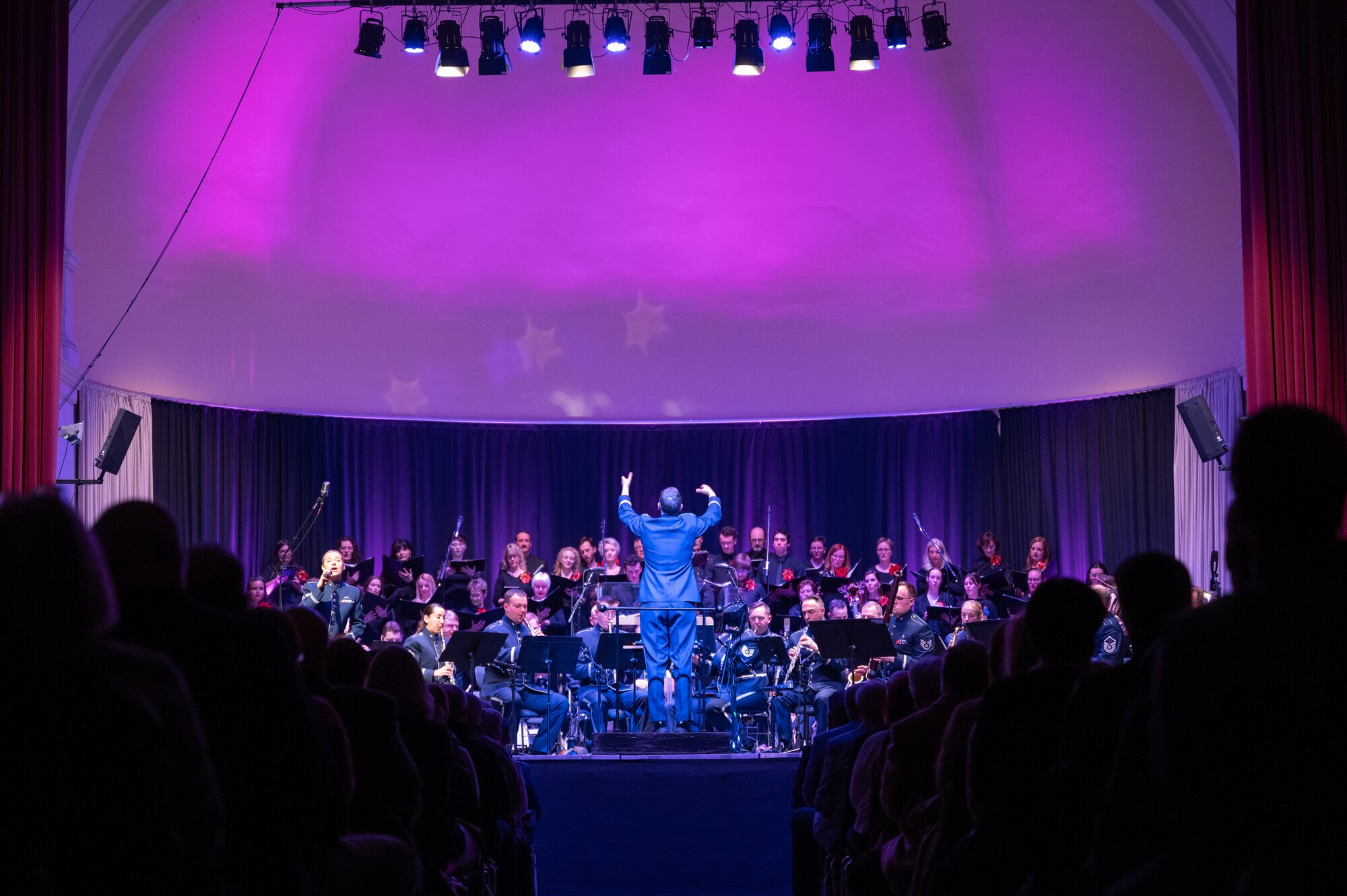The U.S. Air Forces in Europe - Air Forces Africa Band and the Rheinland-Pfalz International Choir perform for an audience of military members and German nationals during the Kaiserslautern Military Community Christmas concert at the Fruchthalle in Kaiserslautern, Germany, Dec. 13, 2024. The USAFE-AFAFRICA band is directed by U.S. Air Force Capt. Brian O’Donnell, U.S. Air Forces in Europe - Air Forces Africa flight commander, with the participation of solo vocalist, Senior Airman Natalie Angst. (U.S. Air Force photo by Senior Airman Renan Arredondo)