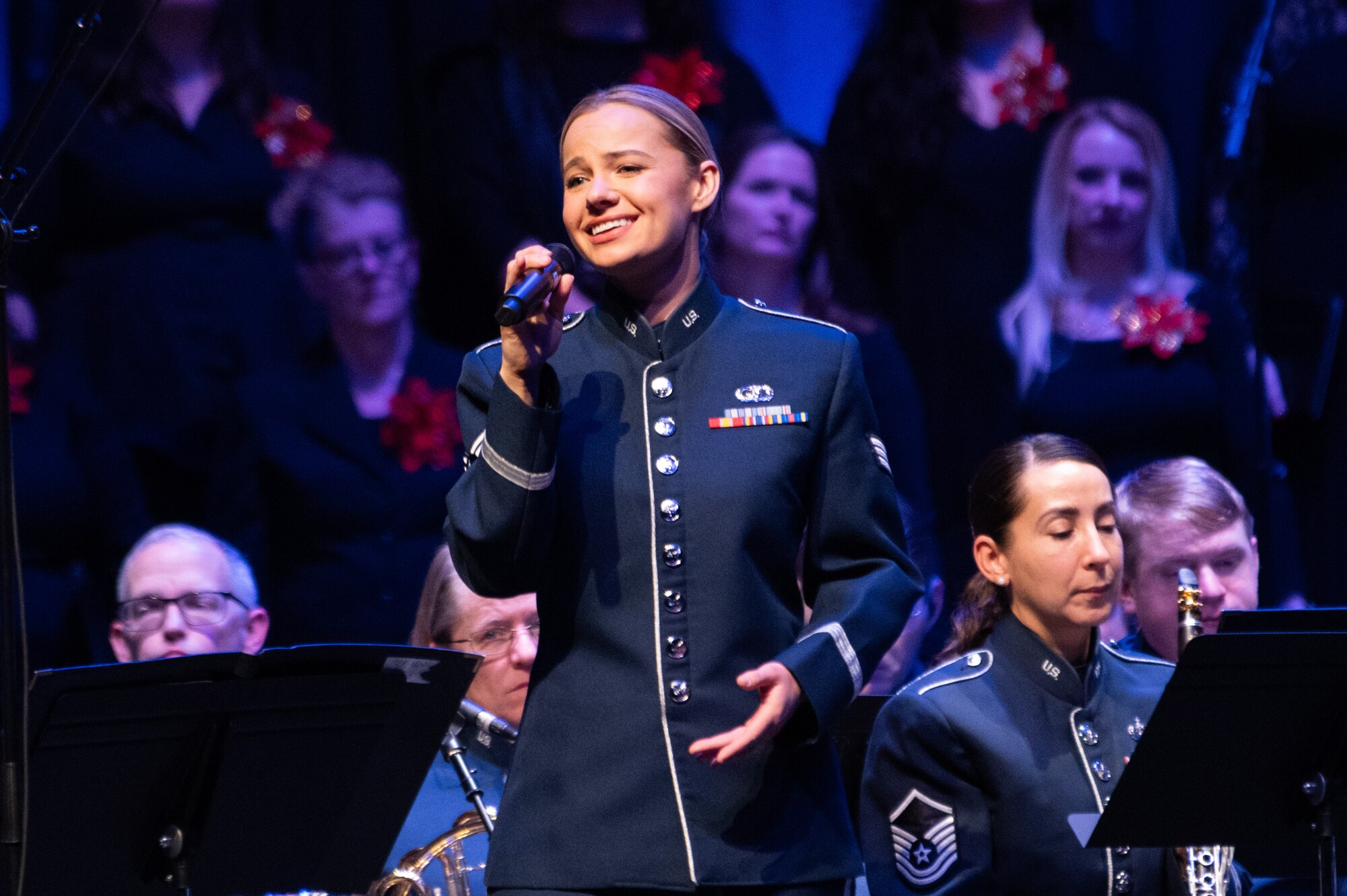 U.S. Air Force Senior Airman Natalie Angst, U.S. Air Forces in Europe - Air Forces Africa Band vocalist, sings during the Kaiserslautern Military Community Christmas concert at the Fruchthalle in Kaiserslautern, Germany, Dec. 13, 2024. These concerts offer a personal stage for cultural exchange and fellowship of musical traditions between the U.S. Air Force musicians and European audiences. (U.S. Air Force photo by Senior Airman Renan Arredondo)