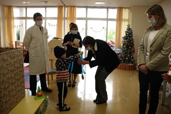 241217-N-DO281-1004 OKINAWA, Japan (Dec. 17, 2024) – Capt. Kathleen Cooperman, commanding officer, Navy Medicine Readiness and Training Command Okinawa, receives a thank you gift during a toy dive at Nambu Medical Center & Nambu Children’s Medical Center in Okinawa, Japan, Dec. 17, 2024. (U.S. Navy photo by Mass Communication Specialist 1st Class Trey Fowler)