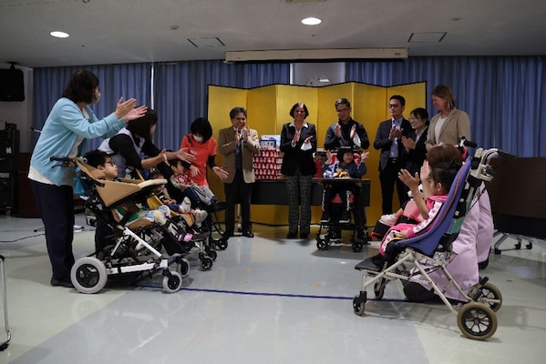 241217-N-DO281-1006 OKINAWA, Japan (Dec. 17, 2024) – Capt. Kathleen Cooperman, commanding officer, Navy Medicine Readiness and Training Command Okinawa, center, engages with children in Okinawa Southern Medical and Rehabilitation Center during a toy drive in Okinawa, Japan, Dec. 17, 2024. (U.S. Navy photo by Mass Communication Specialist 1st Class Trey Fowler)