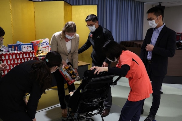 241217-N-DO281-1008 OKINAWA, Japan (Dec. 17, 2024) – Cmdr. Amy Aparicio gives out toys to children during a toy dive at Okinawa Southern Medical and Rehabilitation Center in Okinawa, Japan, Dec. 17, 2024. (U.S. Navy photo by Mass Communication Specialist 1st Class Trey Fowler)