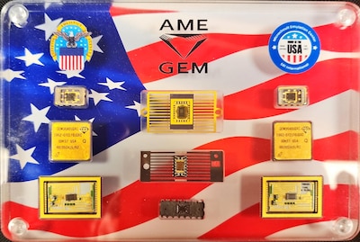 A sampling of microcircuits inside a plastic case with a flag pattern behind them.
