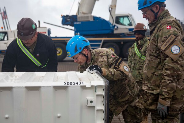 Sailors from NCHB-10 and members of the Royal Danish Navy transfer ammunition during the NATO-led maritime vigilance activity Neptune Strike.