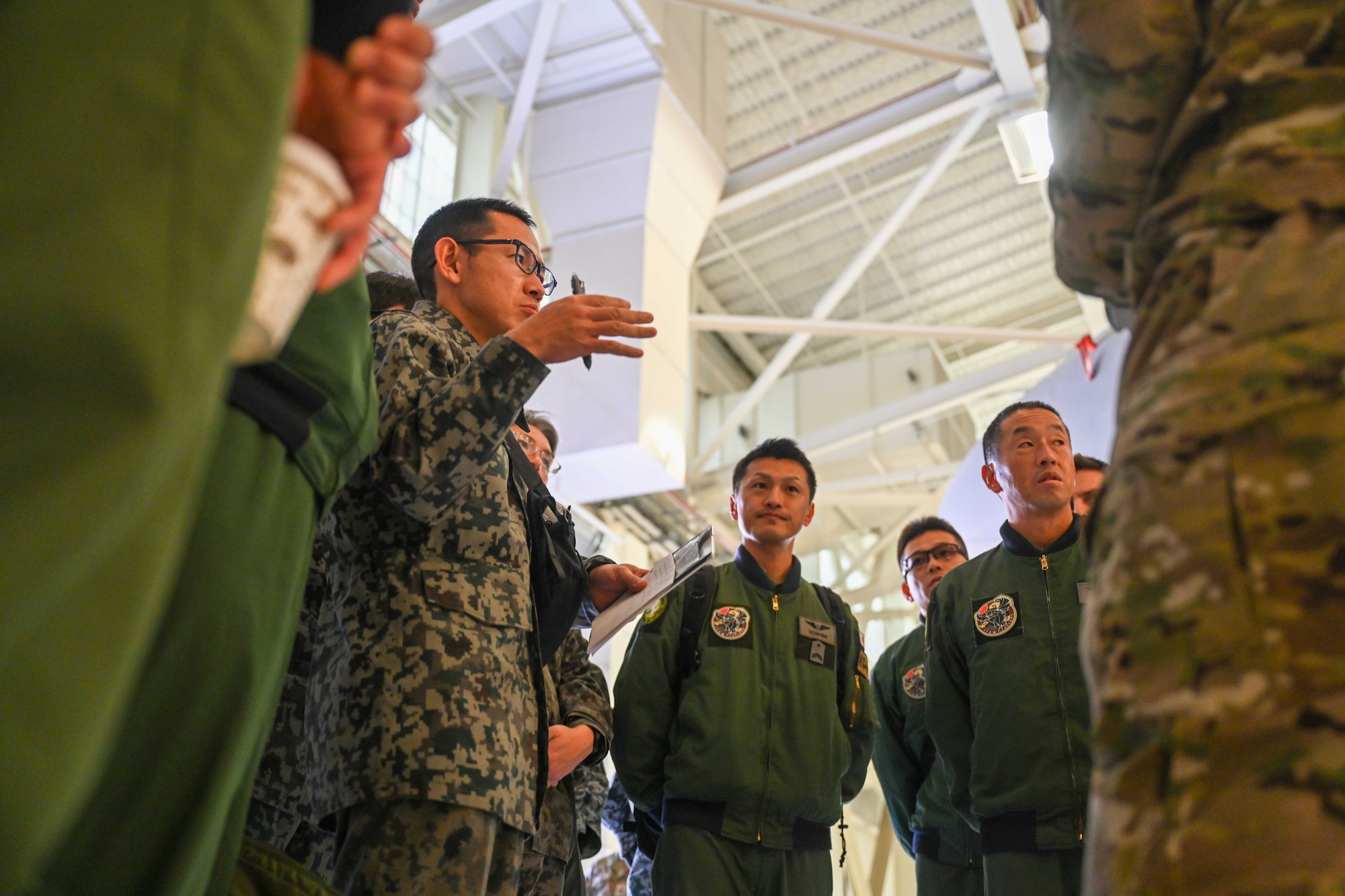 People group around to discuss operational capabilities relating to a KC-46 refueling airplane.