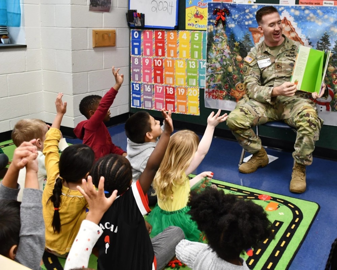 Sgt. 1st Class Ryan Carter reads holiday books with students at Anderson Creek Primary school on Tuesday, December 17, 2024.