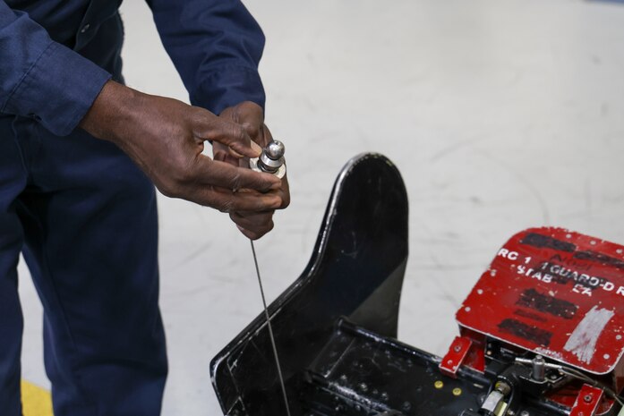 Charlie Toomer, 9th Maintenance Squadron egress systems craftsman, shows the line that can be pulled by pilots to initiate ejection should an emergency occur during flight at Beale Air Force Base, Dec. 2, 2024.