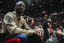 U.S. Marine Corps Sgt. Dennis Maina, assistant for Officer Selection Team San Diego, Recruiting Station San Diego, poses for a photograph during a San Diego State University Men's Basketball game in San Diego, California, Dec. 11, 2024. Maina was recognized as the guest of honor during the game. The guest of honor received special recognition including a formal introduction, reserved seating and participation in game-day activities. (U.S. Marine Corps photo by Cpl. Alejandro Fernandez)