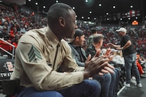U.S. Marine Corps Sgt. Dennis Maina, assistant for Officer Selection Team San Diego, Recruiting Station San Diego, watches the San Diego State University Men's Basketball game in San Diego, California, Dec. 11, 2024. Maina was recognized as the guest of honor during the game. The guest of honor received special recognition including a formal introduction, reserved seating and participation in game-day activities. (U.S. Marine Corps photo by Cpl. Alejandro Fernandez)