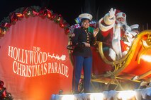 U.S. Marine Corps Sgt. Jazmin Camacho, a canvassing recruiter with Recruiting Sub-Station Fullerton, Recruiting Station Orange County, rides on a float with Santa Clause during the 92nd Hollywood Christmas Parade in Hollywood, California, Dec. 1, 2024. The mission of the Toys for Tots Holiday Program is to collect new, unwrapped toys, books, and other gifts and distribute them to less fortunate children at Christmastime. The Hollywood Christmas Parade is an annual American parade held on the Sunday after Thanksgiving in Hollywood; it follows a 3.5-mile route along Hollywood Boulevard, then back along Sunset Boulevard, featuring various celebrities. (U.S. Marine Corps photo by Cpl. Fred Garcia)
