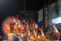 U.S. Marine Corps Sgt. Jazmin Camacho, a canvassing recruiter with Recruiting Sub-Station Fullerton, Recruiting Station Orange County, left, and U.S. Marine Corps Gunnery Sgt. Seth Kornely, a paraloft chief with 3rd Air Naval Gunfire Liaison Company, ride on a float with Santa Clause during the 92nd Hollywood Christmas Parade in Hollywood, California, Dec. 1, 2024. The mission of the Toys for Tots Holiday Program is to collect new, unwrapped toys, books, and other gifts and distribute them to less fortunate children at Christmastime. The Hollywood Christmas Parade is an annual American parade held on the Sunday after Thanksgiving in Hollywood; it follows a 3.5-mile route along Hollywood Boulevard, then back along Sunset Boulevard, featuring various celebrities. (U.S. Marine Corps photo by Cpl. Fred Garcia)