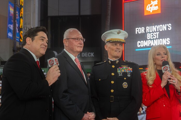 Hollywood Christmas Parade hosts Dean Cain and Laura McKenzie introduce retired U.S. Marine Corps Lt. Gen. James Laster, president and CEO of the Toys for Tots Foundation, and U.S. Marine Corps Lt. Gen. Leonard Anderson, commander of U.S. Marine Corps Forces Reserve and U.S. Marine Corps Forces South, during the 92nd Hollywood Christmas Parade in Hollywood, California, Dec. 1, 2024. The mission of the Toys for Tots Holiday Program is to collect new, unwrapped toys, books, and other gifts and distribute them to less fortunate children at Christmastime. The Hollywood Christmas Parade is an annual American parade held on the Sunday after Thanksgiving in Hollywood; it follows a 3.5-mile route along Hollywood Boulevard, then back along Sunset Boulevard, featuring various celebrities. (U.S. Marine Corps photo by Cpl. Fred Garcia)