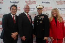 Hollywood Christmas Parade hosts Dean Cain and Laura McKenzie walk the red carpet with retired U.S. Marine Corps Lt. Gen. James Laster, president and CEO of the Toys for Tots Foundation, and U.S. Marine Corps Lt. Gen. Leonard Anderson, commander of U.S. Marine Corps Forces Reserve and U.S. Marine Corps Forces South, during the 92nd Hollywood Christmas Parade in Hollywood, California, Dec. 1, 2024. The mission of the Toys for Tots Holiday Program is to collect new, unwrapped toys, books, and other gifts and distribute them to less fortunate children at Christmastime. The Hollywood Christmas Parade is an annual American parade held on the Sunday after Thanksgiving in Hollywood; it follows a 3.5-mile route along Hollywood Boulevard, then back along Sunset Boulevard, featuring various celebrities. (U.S. Marine Corps photo by Cpl. Fred Garcia)